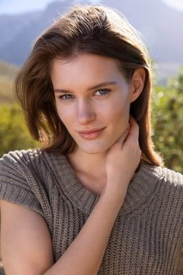 Femme en extérieur avec look naturel devant un décor de montagne