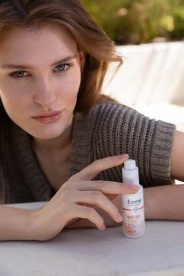 Femme présente fluide anti-UV dans le jardin