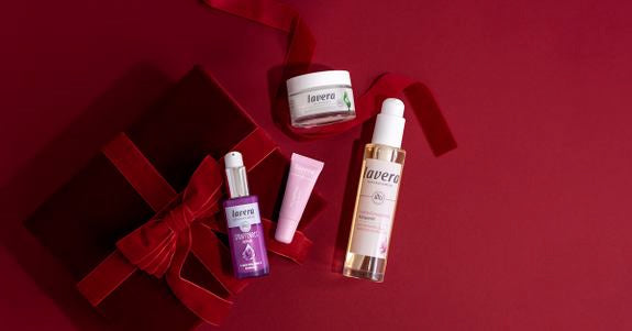 Produits de soin lavera avec boîte cadeau rouge sur fond rouge foncé