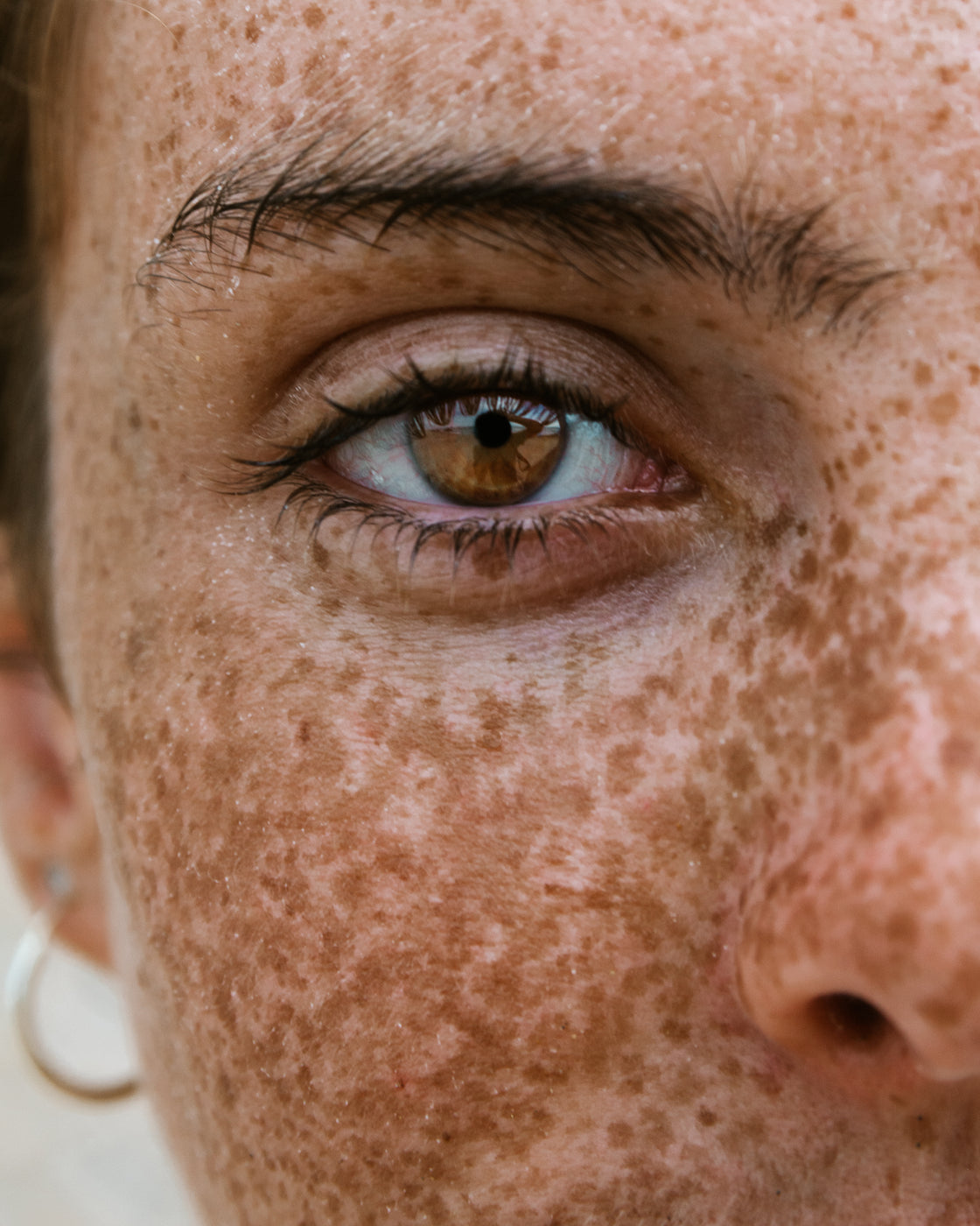 Gros plan du contour des yeux d'un visage féminin naturel avec taches de rousseur