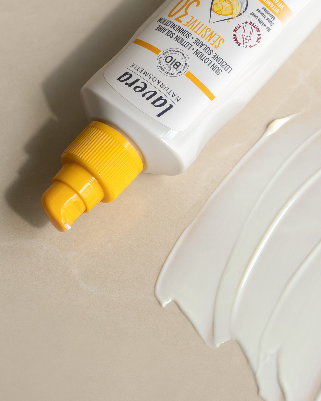 lavera Sensitiv lait solaire SPF 30 avec bouchon jaune et texture produit