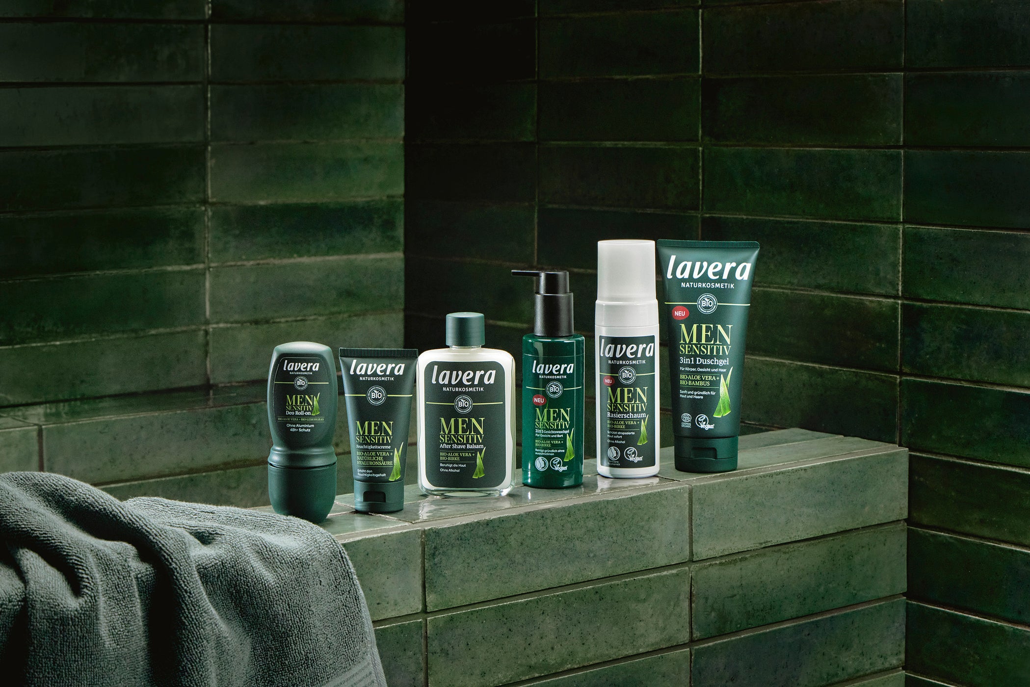 Gamme de soins lavera men alignés devant carreaux vert foncé