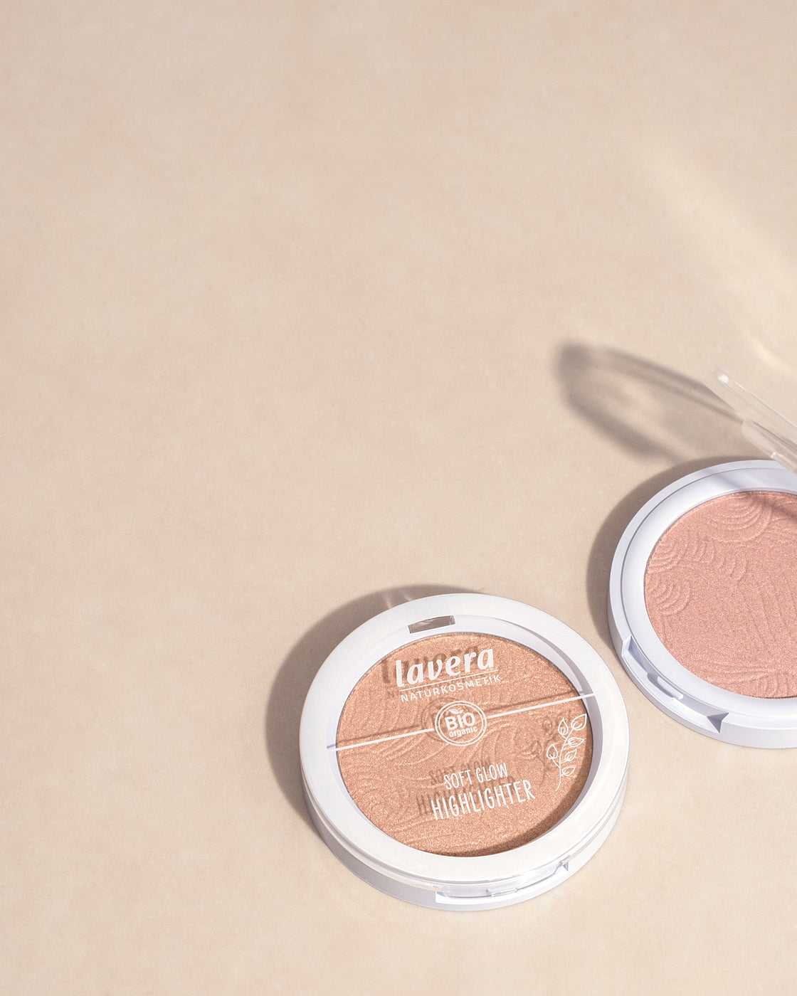 Soft Glow Highlighter posé devant fond beige