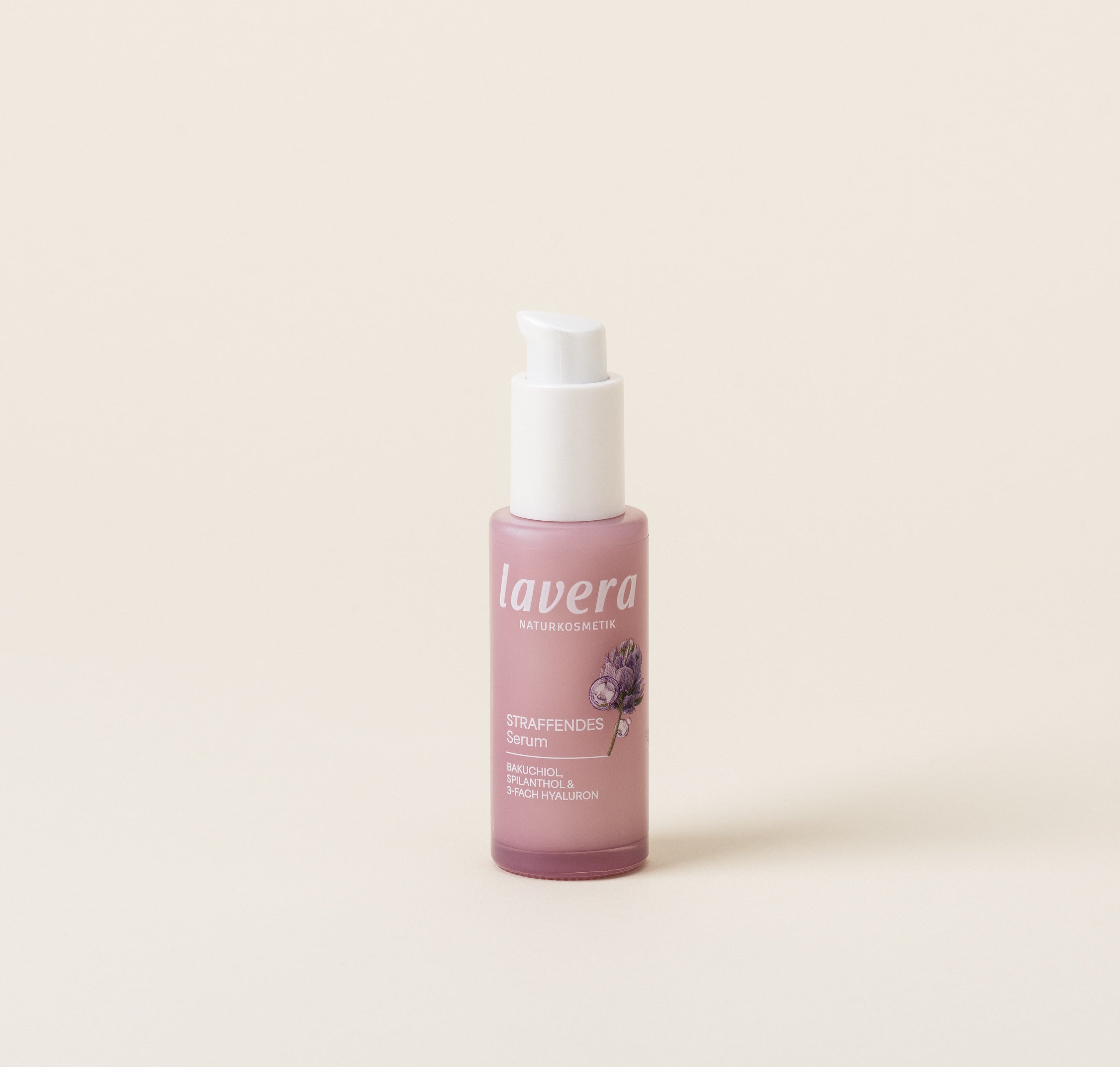 Une bouteille rose de Sérum Raffermissant lavera se trouve devant un arrière-plan clair et neutre.