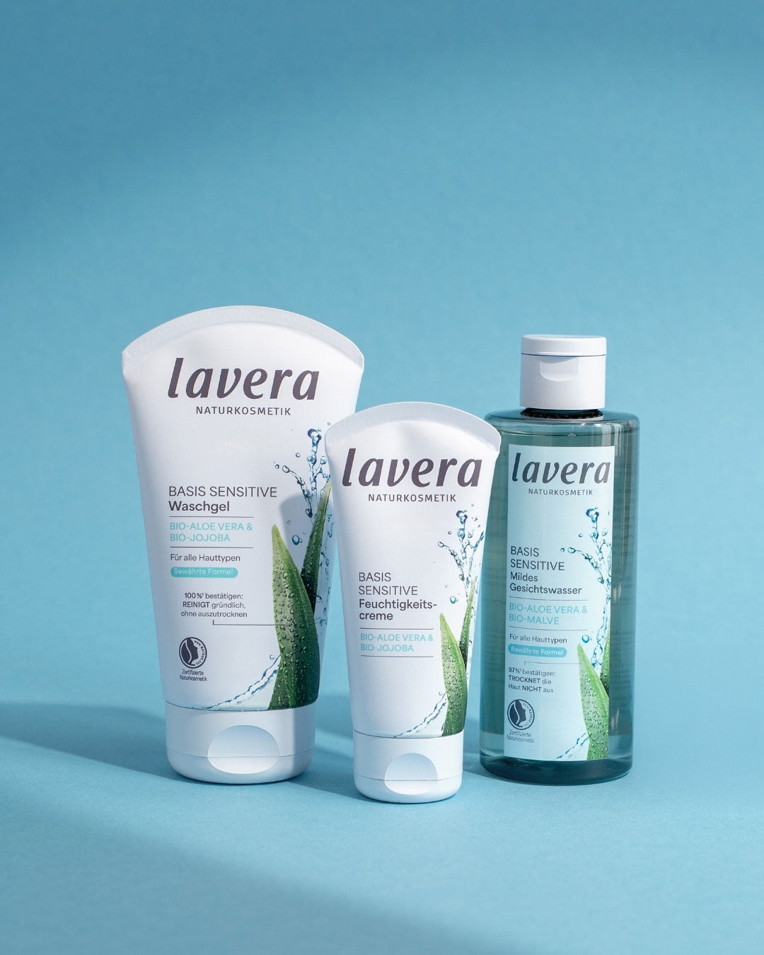 lavera Basis Sensitive Wasschgel, Feuchtigkeitscreme und Gesichtswasser vor blauem Hintergrund