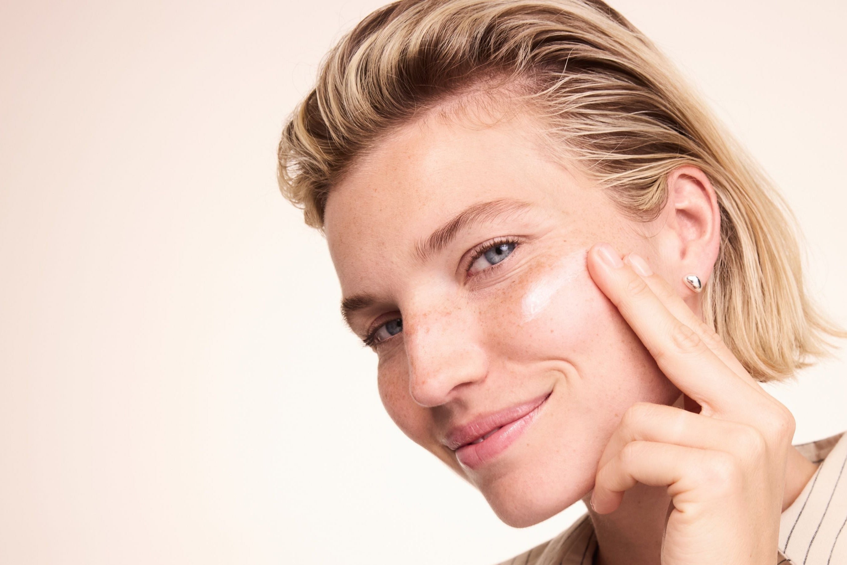 Femme appliquant la crème sur la joue