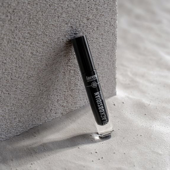 Mascara lavera Black Obsidian appuyé contre une pierre grise