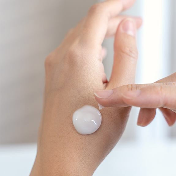 Crème appliquée en goutte sur le dos de la main