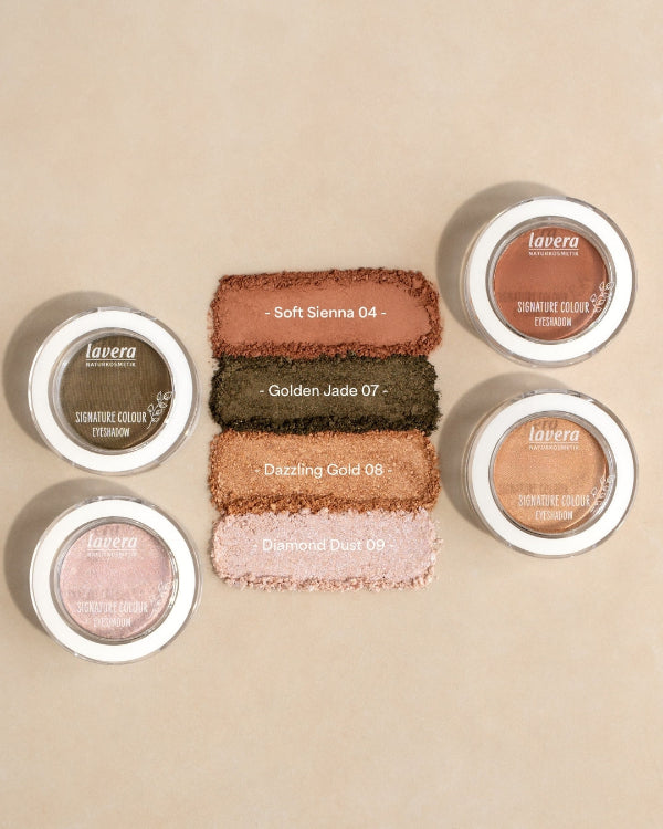 Vier lavera Lidschatten-Swatches in den Farben Soft Sienna, Golden Jade, Dazzling Gold und Diamond Dust neben den Produktdöschen.