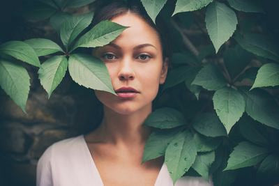 Portrait d'une femme encadrée de feuilles vertes
