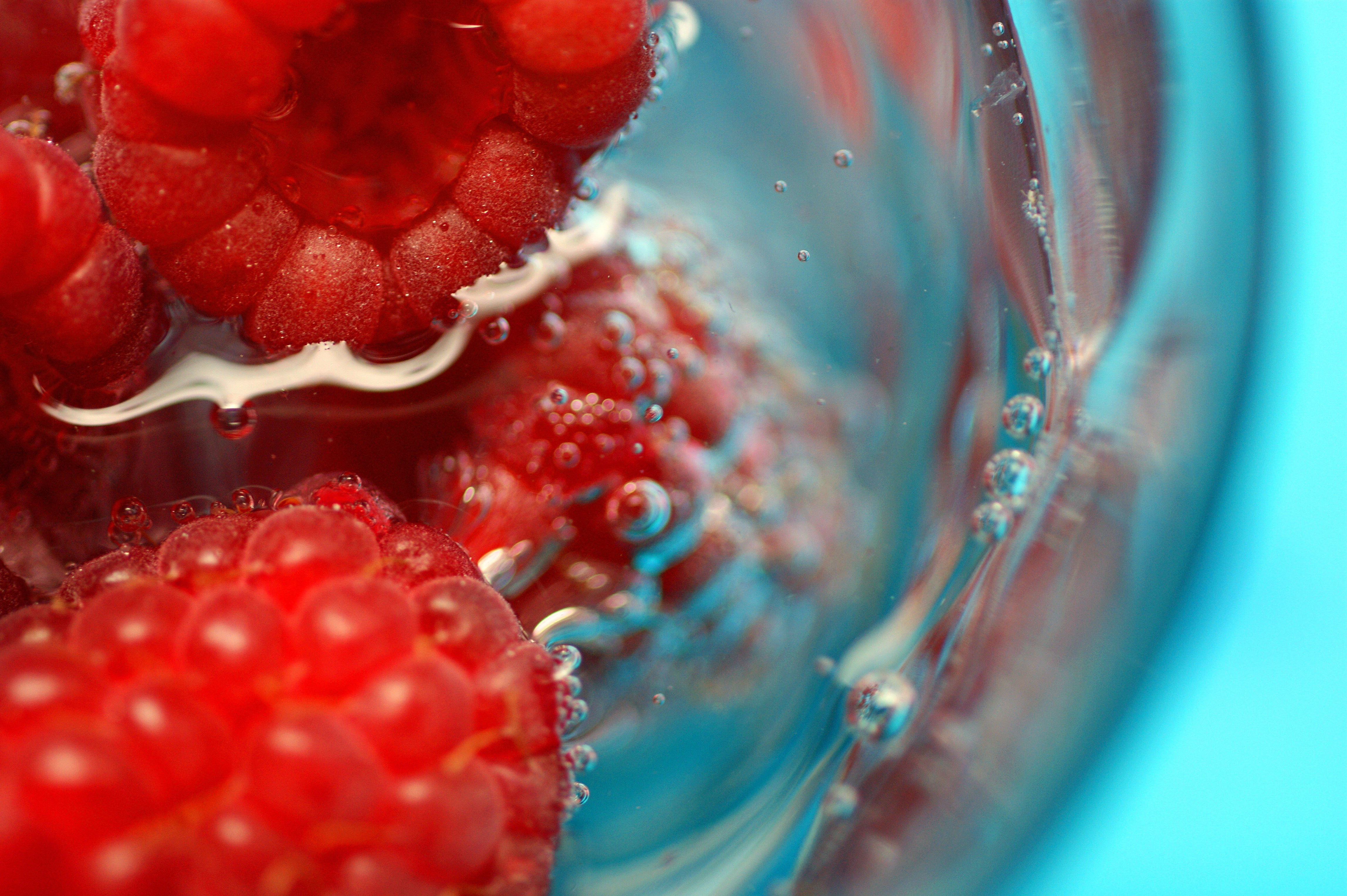 Nahaufnahme von Himbeeren in einem Glas mit Wasser
