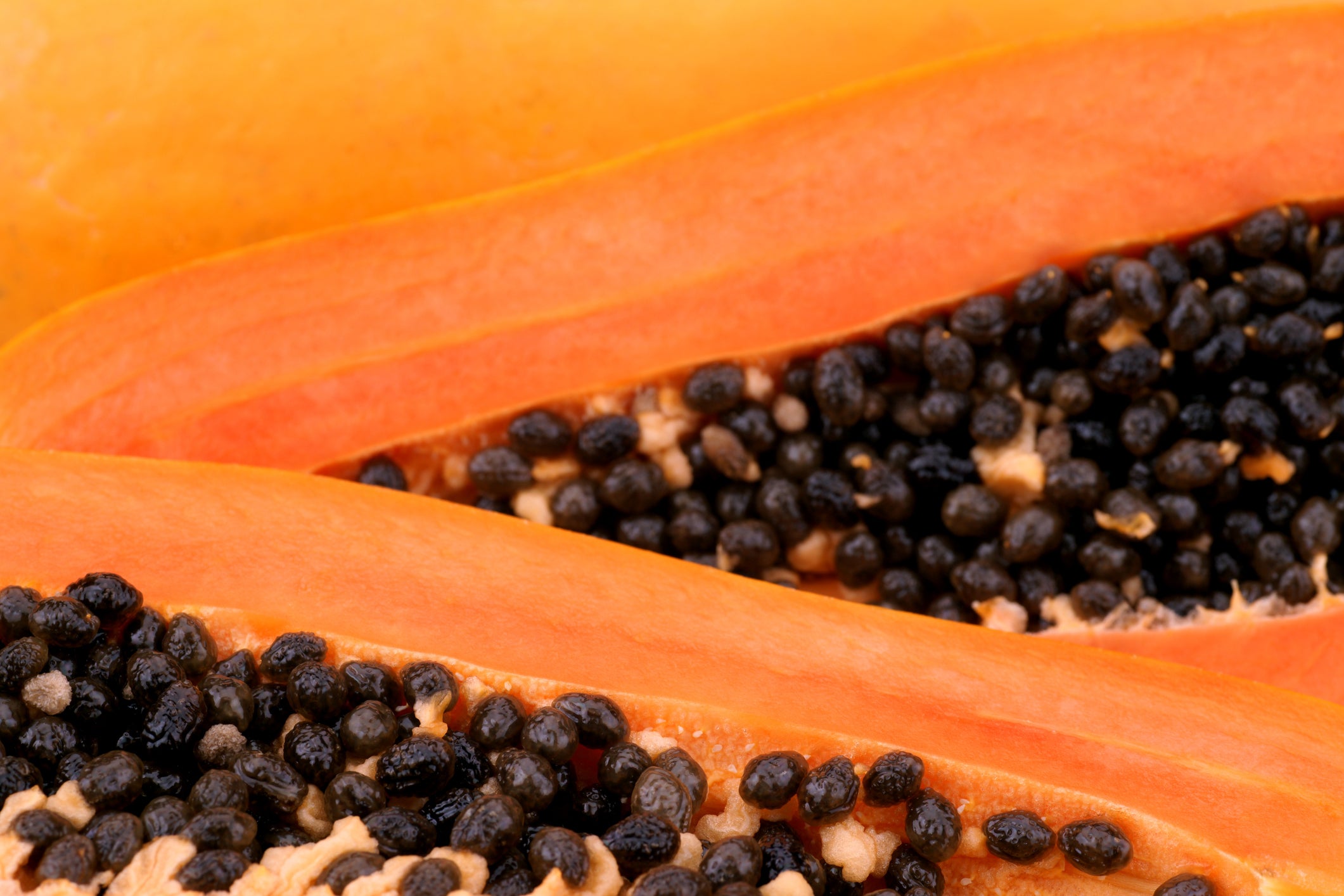 Nahaufnahme von zwei aufgeschnittenen Papaya-Früchten mit Kernen