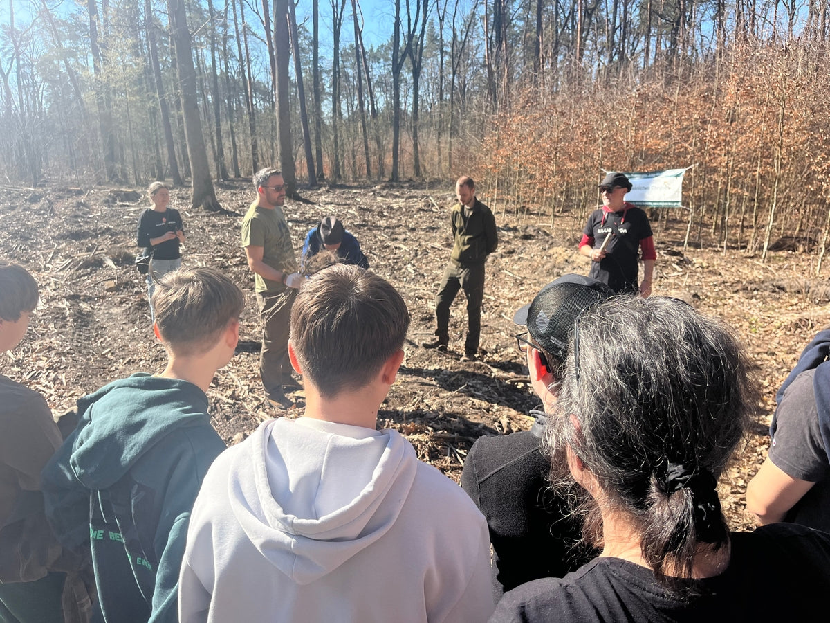 Groupe de personnes composé d'hommes et de femmes en demi-cercle dans la forêt