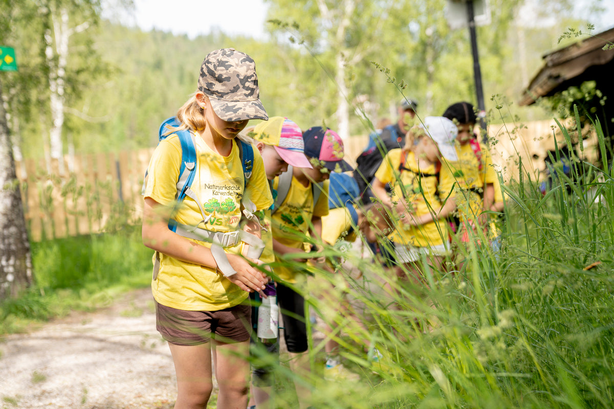 Enfants en t-shirts jaunes avec casquettes debout en plein air