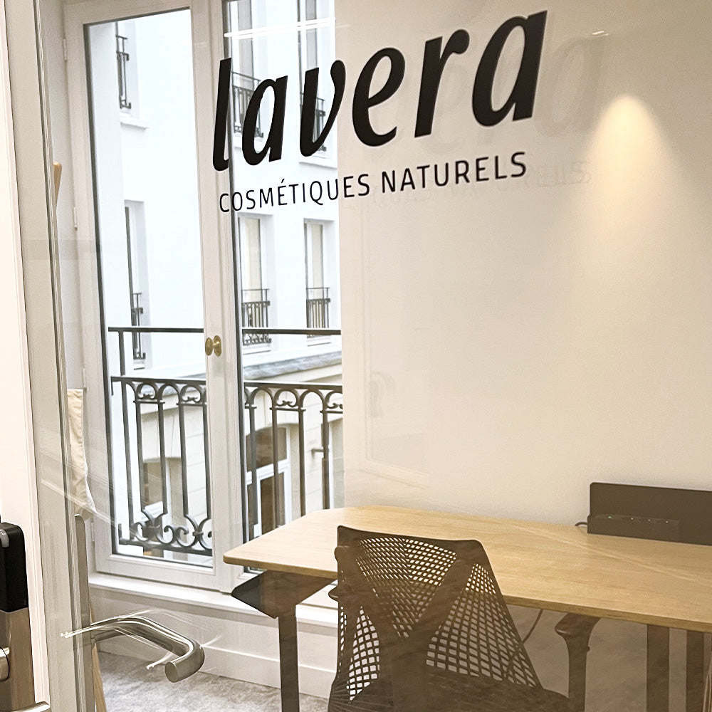 bureau lavera : inscription « Cosmétiques Naturels » sur paroi vitrée, bureau près de la fenêtre