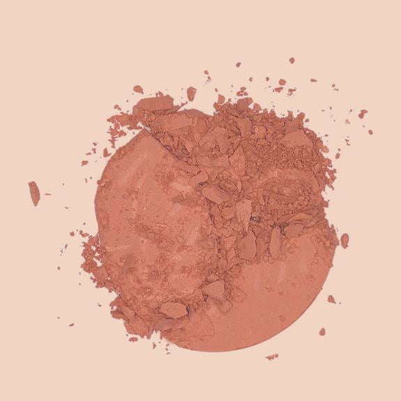 Texture de fard à joues en poudre brisée dans un ton pêche chaud