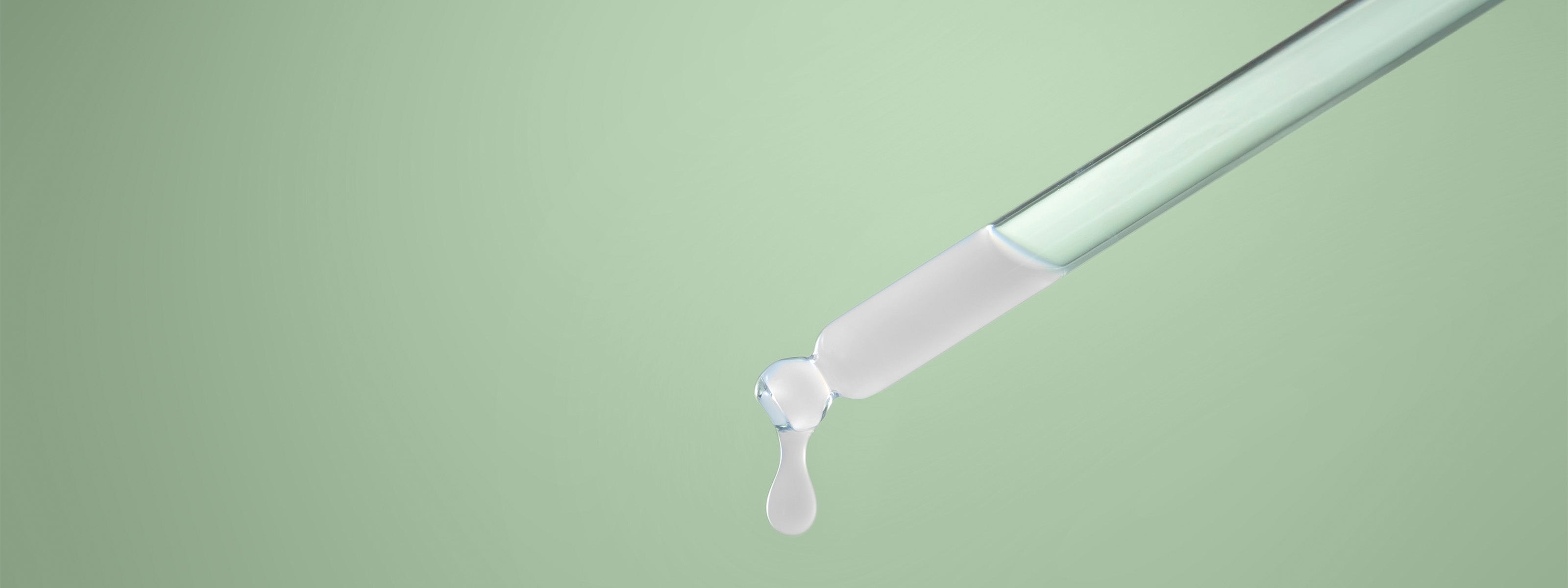 Sérum sortant d'une pipette sur fond vert