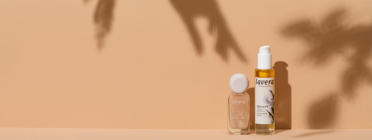Glow Body Oil und Cellulite 2-Phasen Body Serum vor hellem Hintergrund