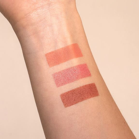 Drei Rouge-Farbstriche in Rosé- und Brauntönen auf einem Unterarm