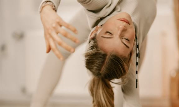 Femme s'étirant sur le côté en vêtements de sport clairs