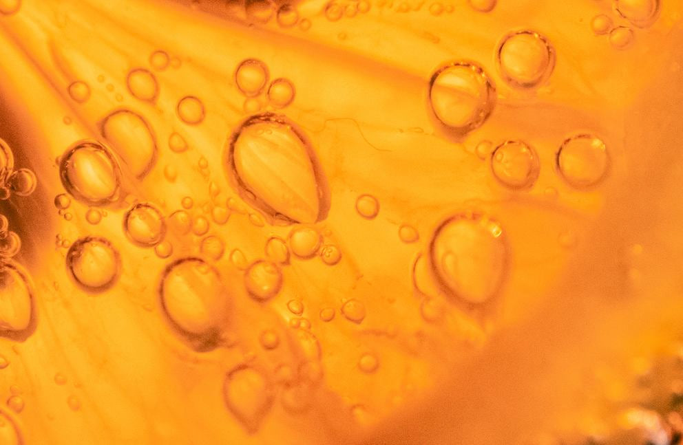 Makro: orangefarbene Öltextur mit Luftblasen, Serum-Hintergrund